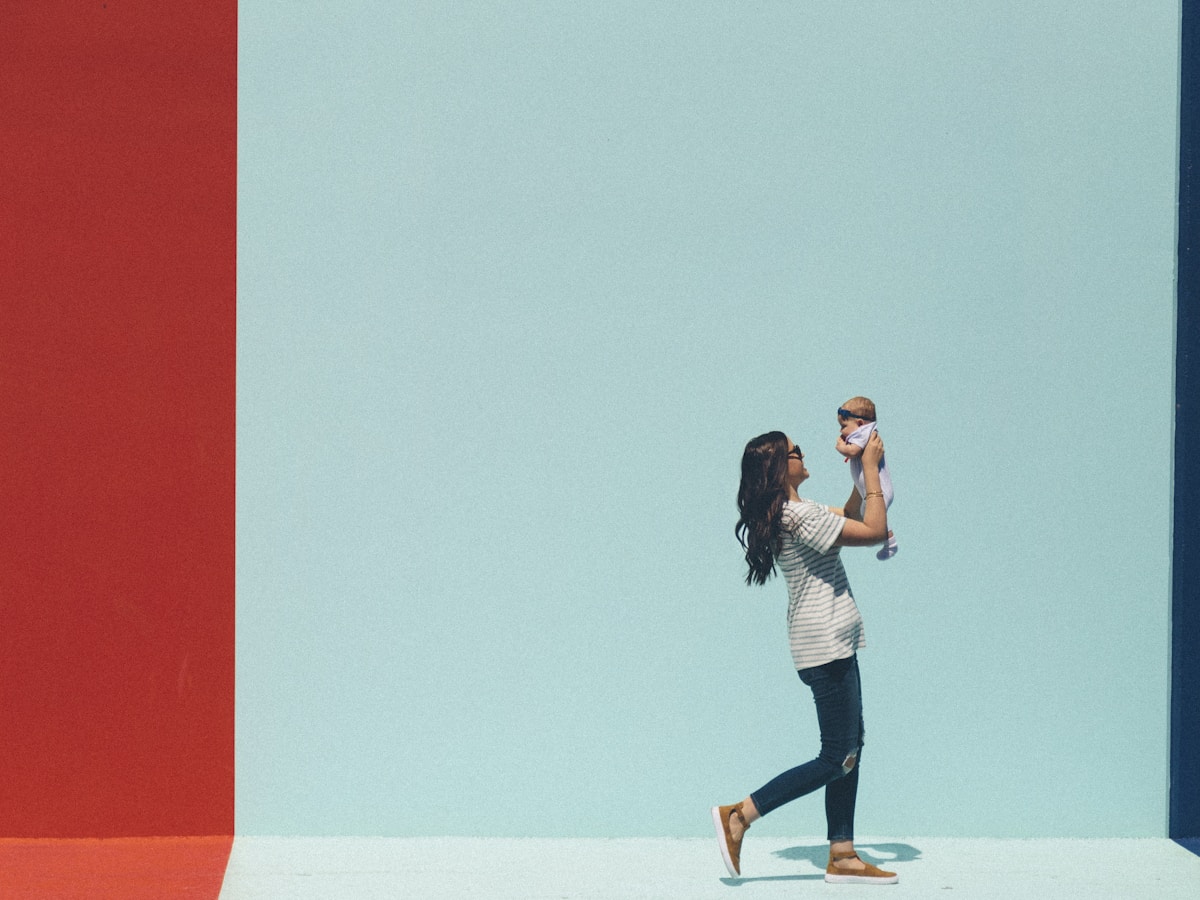 Mãe segurando bebê recém-nascido com luz dourada